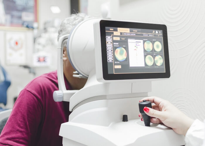 Elderly female patient undergoing an exam with an optical machine